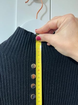 Jersey negro con volantes y botones dorados