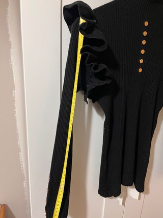 Jersey negro con volantes y botones dorados