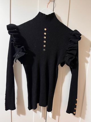 Jersey negro con volantes y botones dorados