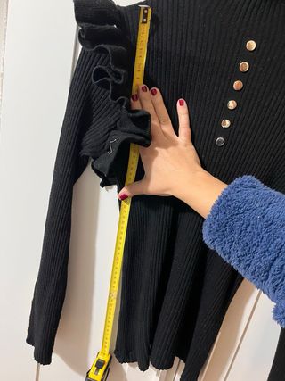 Jersey negro con volantes y botones dorados