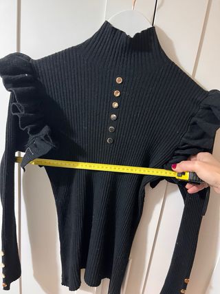 Jersey negro con volantes y botones dorados