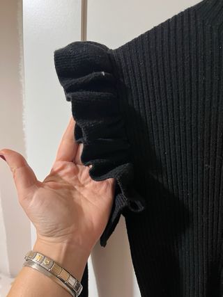 Jersey negro con volantes y botones dorados