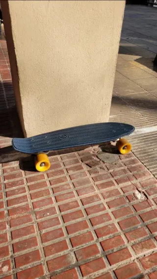 Monopatín azul con ruedas amarillas