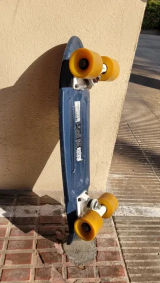 Monopatín azul con ruedas amarillas