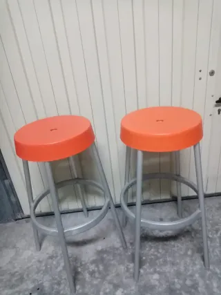 Dos taburetes altos naranja y plata