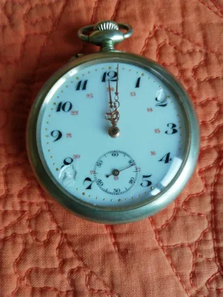 Reloj de bolsillo antiguo y moneda