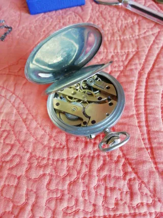 Reloj de bolsillo antiguo y moneda