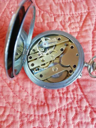 Reloj de bolsillo antiguo y moneda