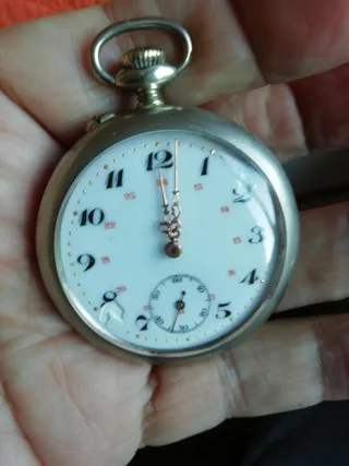 Reloj de bolsillo antiguo y moneda