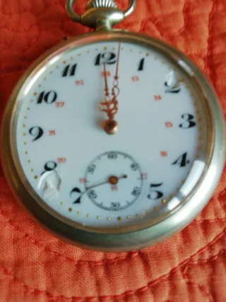 Reloj de bolsillo antiguo y moneda