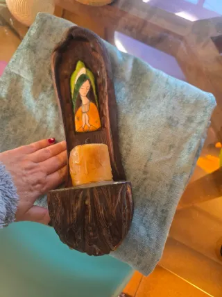 Figura religiosa de madera con vela