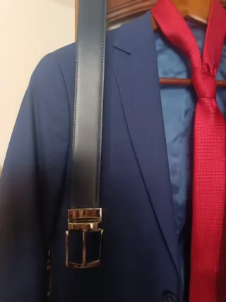 Traje de chaqueta azul con corbata roja, cinturón.
