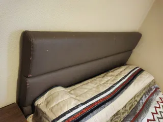 Canapé abatible con colchón y cabecero.