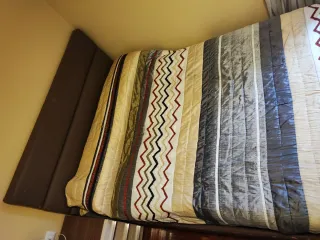 Canapé abatible con colchón y cabecero.