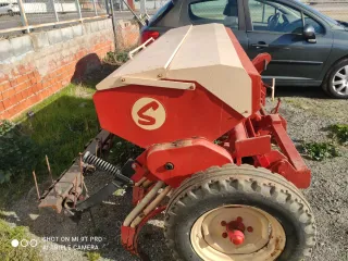 Sembradora agrícola roja y beige