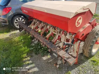 Sembradora agrícola roja y beige