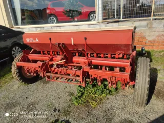 Sembradora agrícola roja y beige