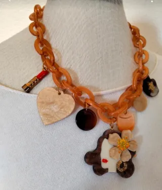 Collar con pendenti da donna e rossetto