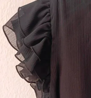 Blusa negra con volantes y lazo