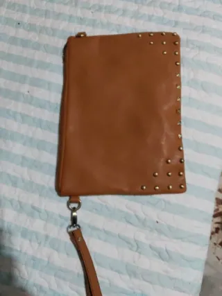 Bolso de mano marrón con tachuelas