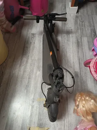 Patinete eléctrico con su cargador.