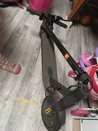 Patinete eléctrico con su cargador.