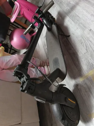 Patinete eléctrico con su cargador.