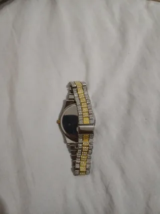 Reloj de pulsera dorado y plateado. No tiene marca