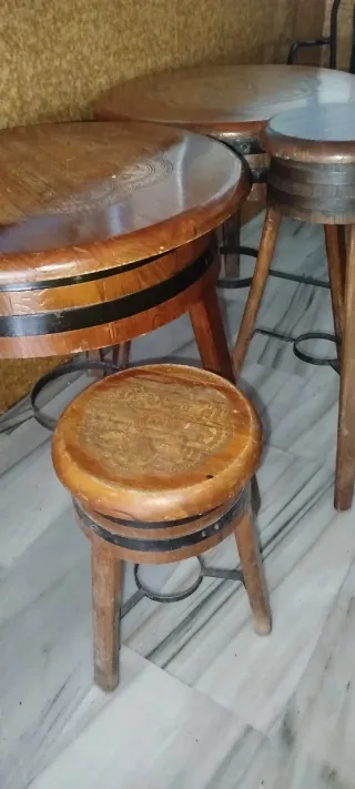 Tavolo rotondo in legno con quattro sgabelli da bar