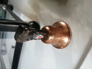 Campana antigua de cobre con oso
