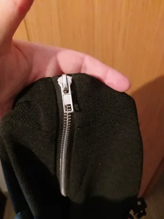 Pantalón negro con cremallera y tiras