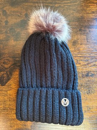 Gorro de lana negro con pompón y detalle dorado