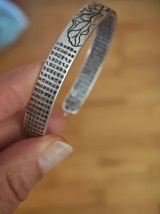 Pulsera plateada con diseño floral