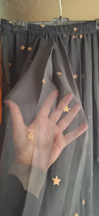 Falda larga negra con estrellas doradas.