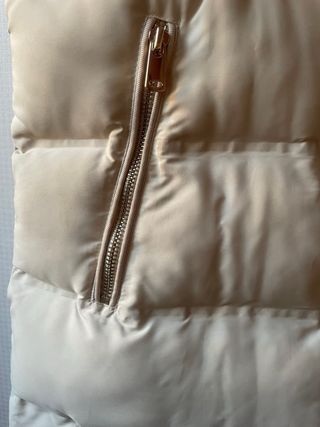 Chaleco acolchado beige con capucha