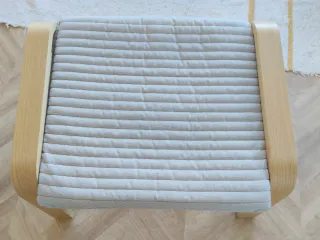 Reposapiés para butaca Poäng madera y tela gris.