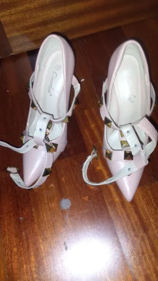 Zapatos de tacón rosa con tachuelas doradas