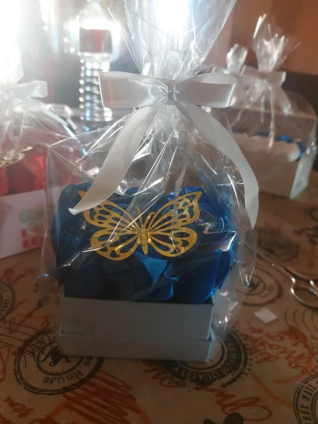 Caja de rosas azules con mariposa