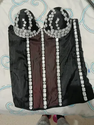 Corpiño negro pedrería,tiene tirantas ,una copa b