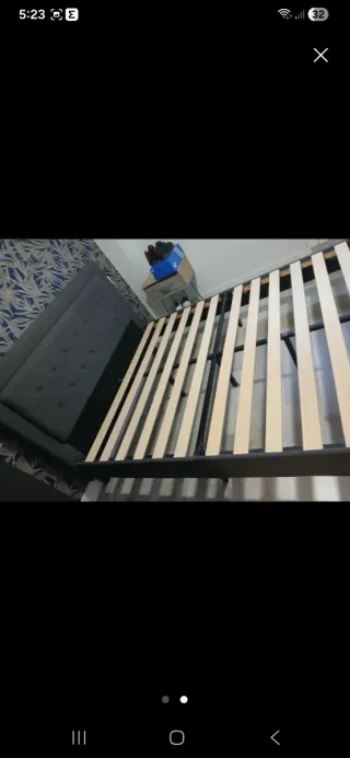 Cama tapizada gris con somier de madera