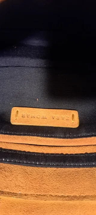 Bolso de ante de color mostaza con cadena.