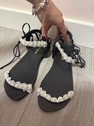 Sandalias planas negras con detalle floral blanco
