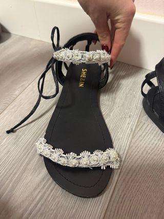 Sandalias planas negras con detalle floral blanco