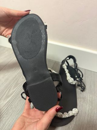 Sandalias planas negras con detalle floral blanco