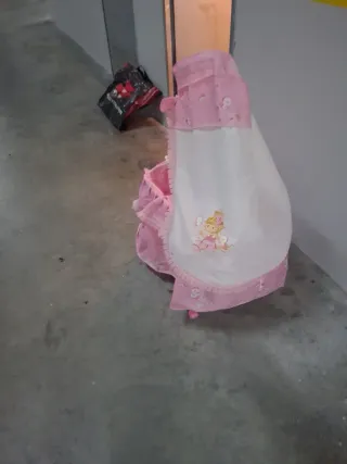 Cuna de bebé rosa con muñeca