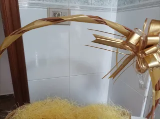 Cesta de mimbre decorada con lazo dorado