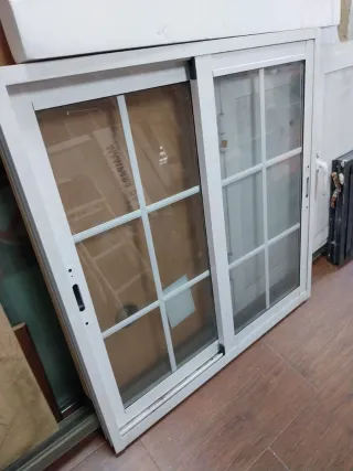 Ventana corredera blanca Climalit con palillería