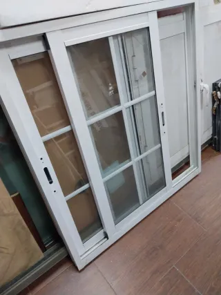 Ventana corredera blanca Climalit con palillería