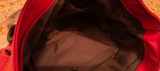 Bolso grande rojo oscuro con varios bolsillos.