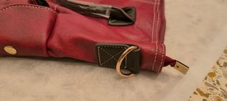 Bolso grande rojo oscuro con varios bolsillos.